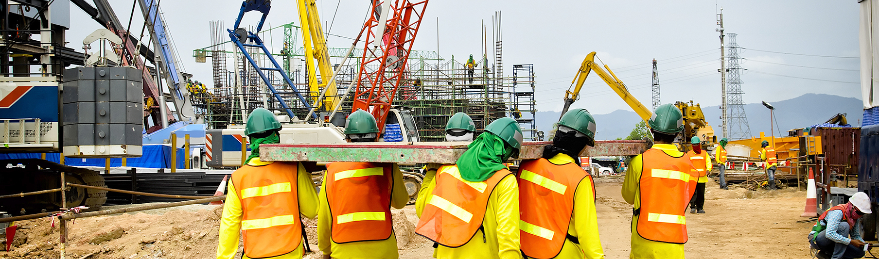 Construction Insurance: Builders lifting something together on a worksite